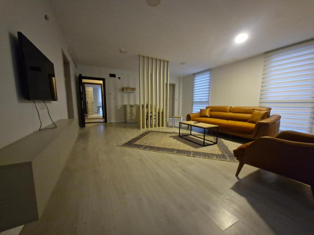 a living room with a couch and a tv at Suiton6 apart otel in İhsaniye