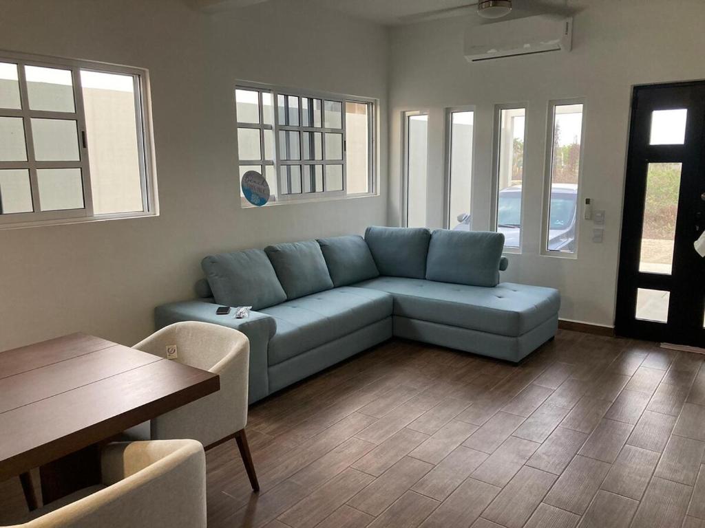 a living room with a blue couch and a table at Brisa Marina in Playa Agua Blanca