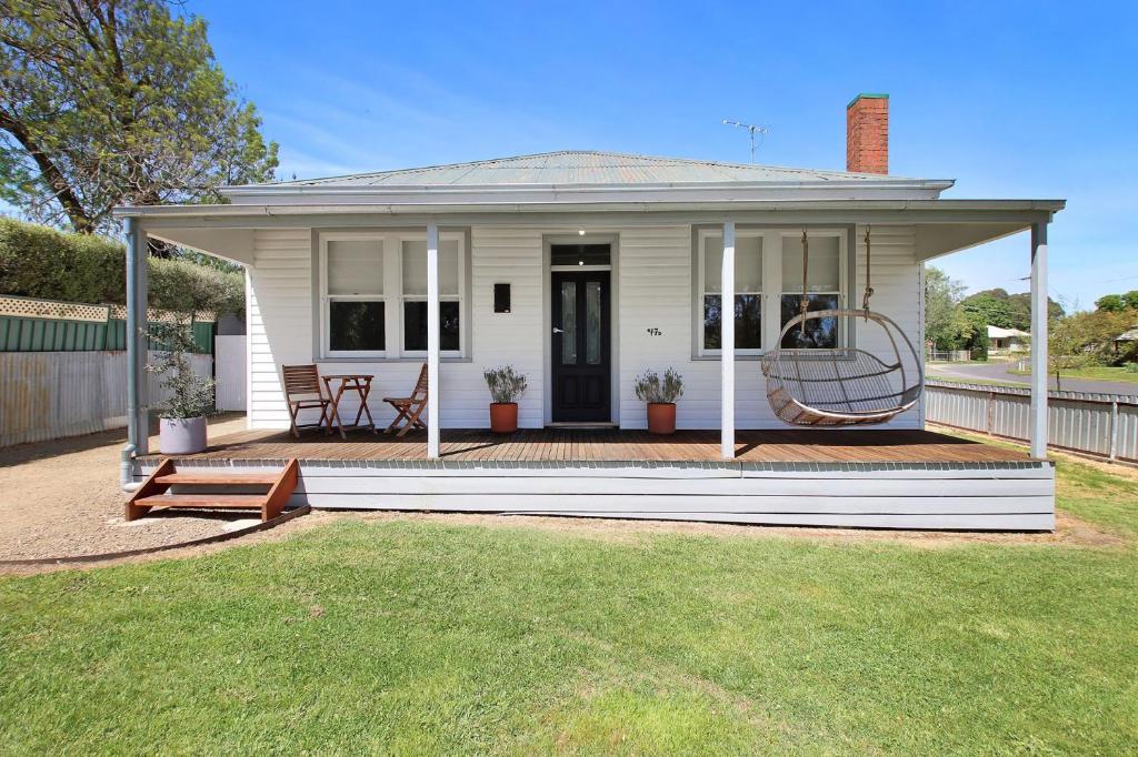 a small white house with a porch and a lawn at The Gums, Beechworth in Beechworth