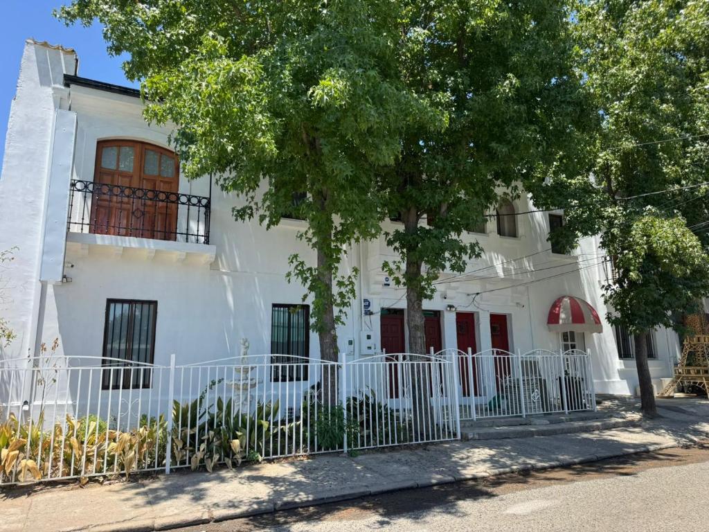 a white house with a fence in front of it at HOSTAL PARIS TALCA in Talca