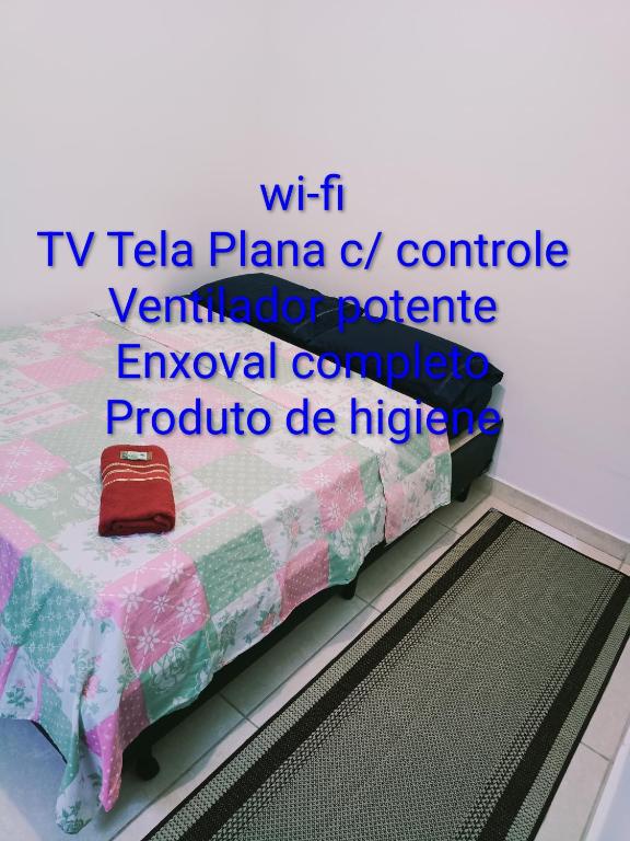 a table with a quilt on it with the words tv tea plana c at Suites Aeroporto in Campinas