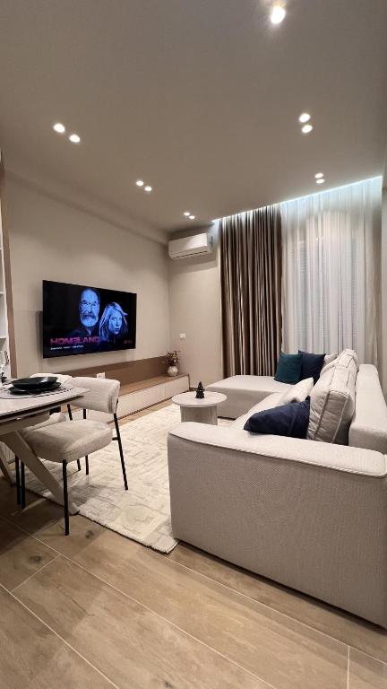 a living room with a couch and a flat screen tv at Luxurios seaside apartment 2 in Durrës