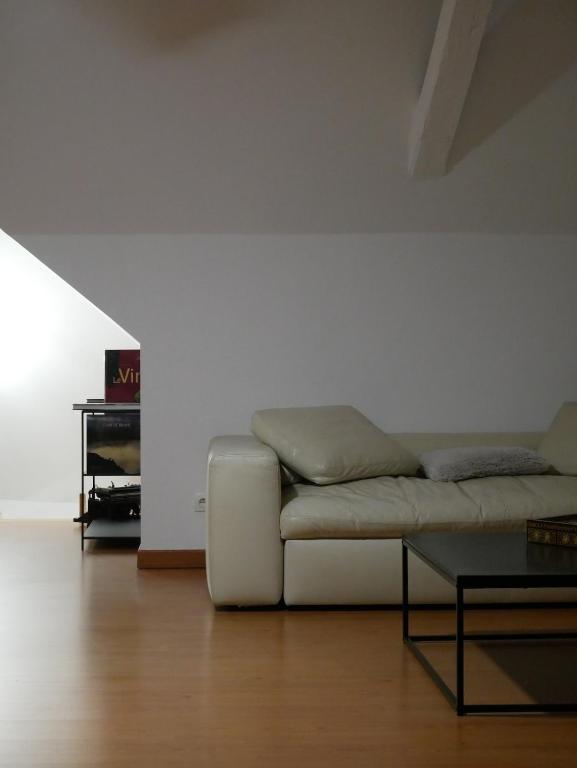 a white living room with a couch and a table at Le Clocher, nice warm and comfortable nest in Sierentz