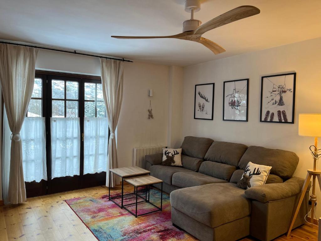 a living room with a couch and a ceiling fan at Les 3 Valls in Llavorsí