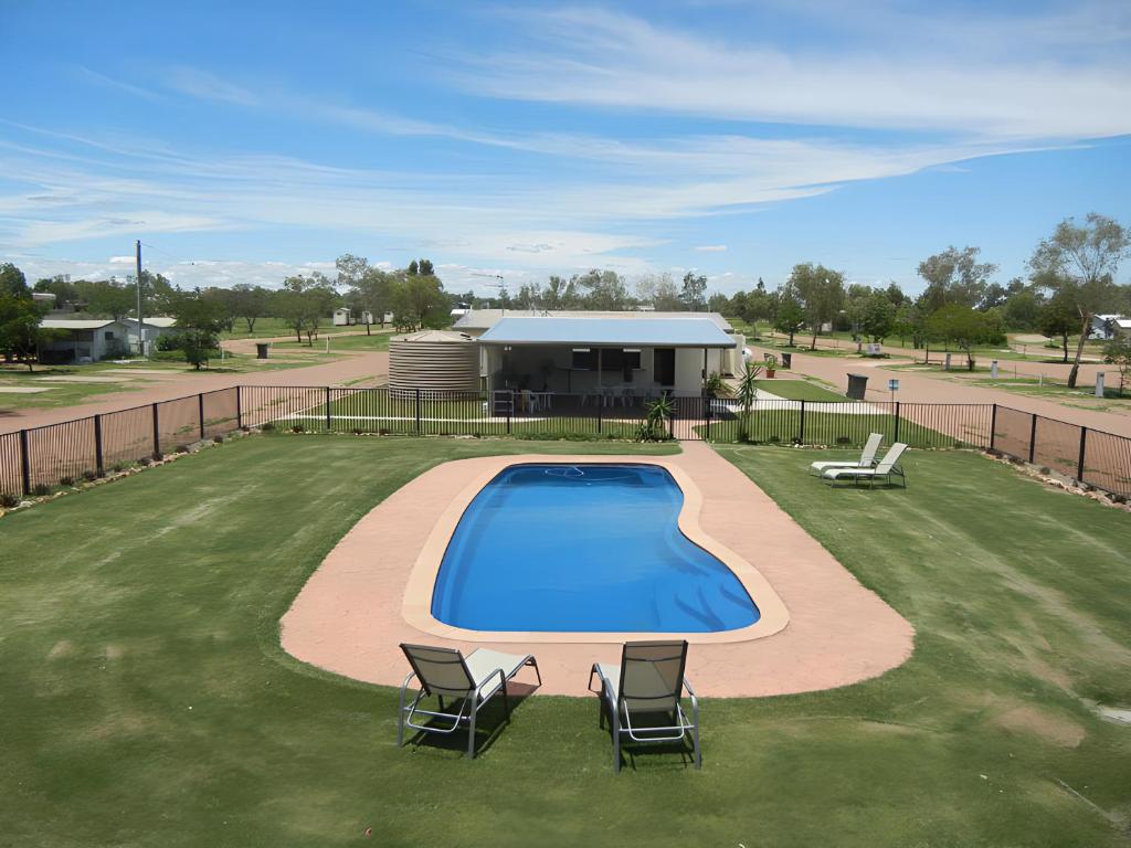 an overhead view of a swimming pool with two chairs at Longreach Tourist Park in Longreach