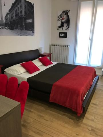 a bedroom with a large bed with a red blanket at B&B Dell'Orso in Bologna