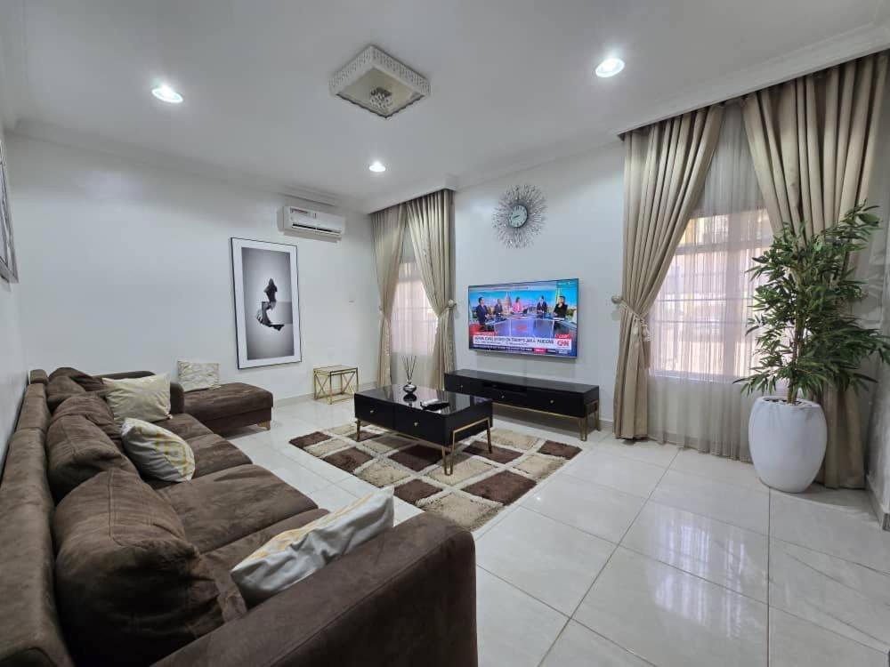 a large living room with a couch and a tv at Pavilion Luxury 4bedroom duplex in Mama