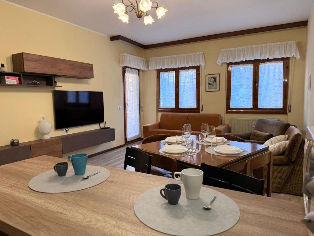 a living room with a table and a dining room at AlipierHome Bernina Gateway Comfort e Spazio vicino al Trenino Rosso in Tirano