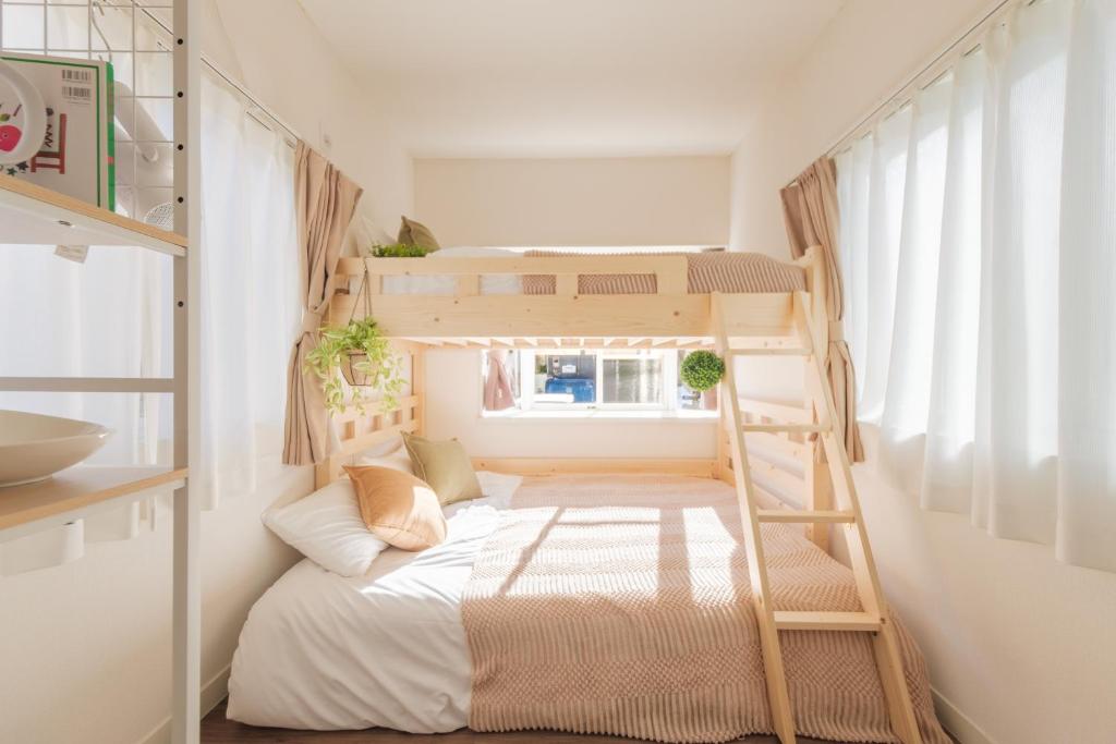 a bunk bed in a small room with a ladder at Hotel Emile 101 in Tachikawa