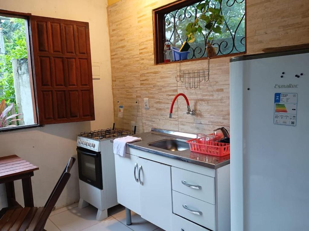 a kitchen with a sink and a refrigerator at Villa Tropical Herbert in Itacaré
