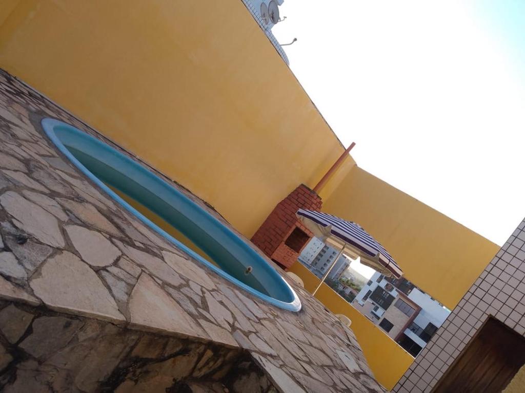 a blue surfboard sitting on the side of a building at Apartamento com piscina e churrasqueira privativas in Cabedelo