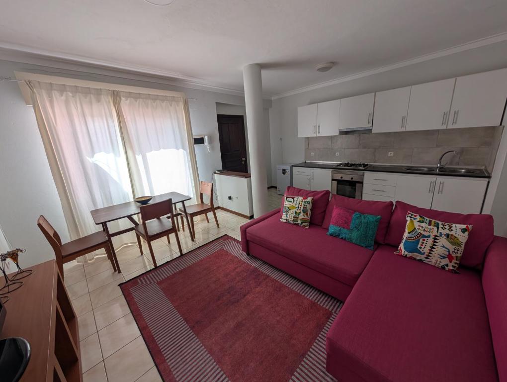 a living room with a purple couch and a kitchen at Apartamento Espargos in Espargos