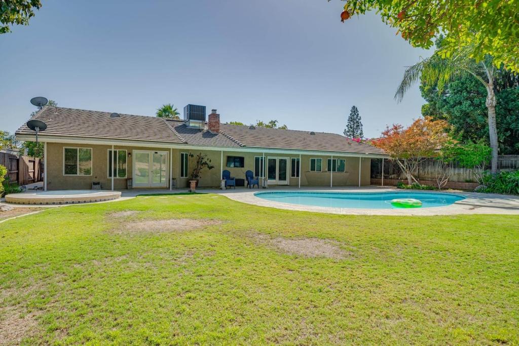 a house with a yard with a swimming pool at Your Poolside Hideaway in Bakersfield