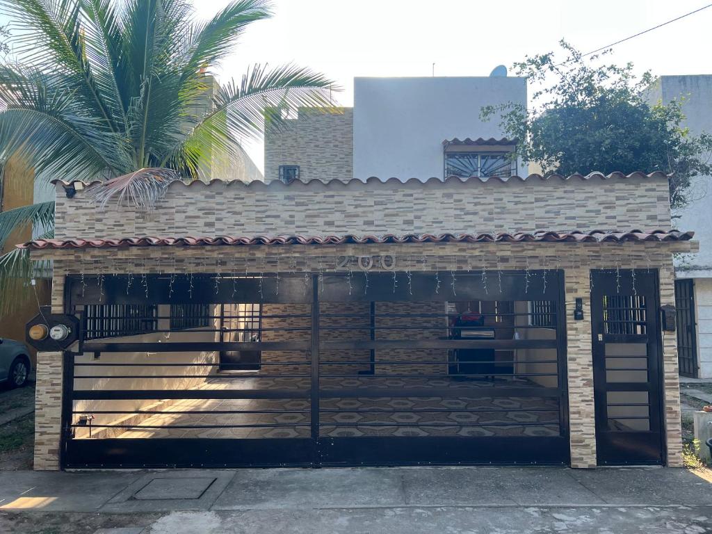 a brick building with a gate and a palm tree at Casa Pacifico Azul in Ixtapa
