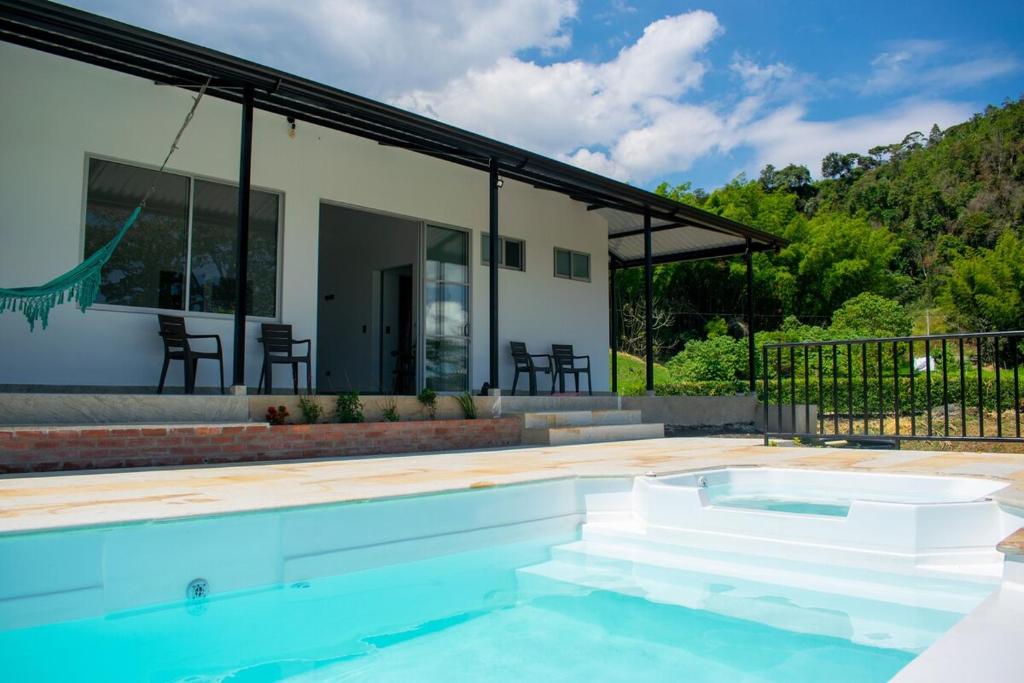 a swimming pool in front of a house at Villa Majo in Nocaima