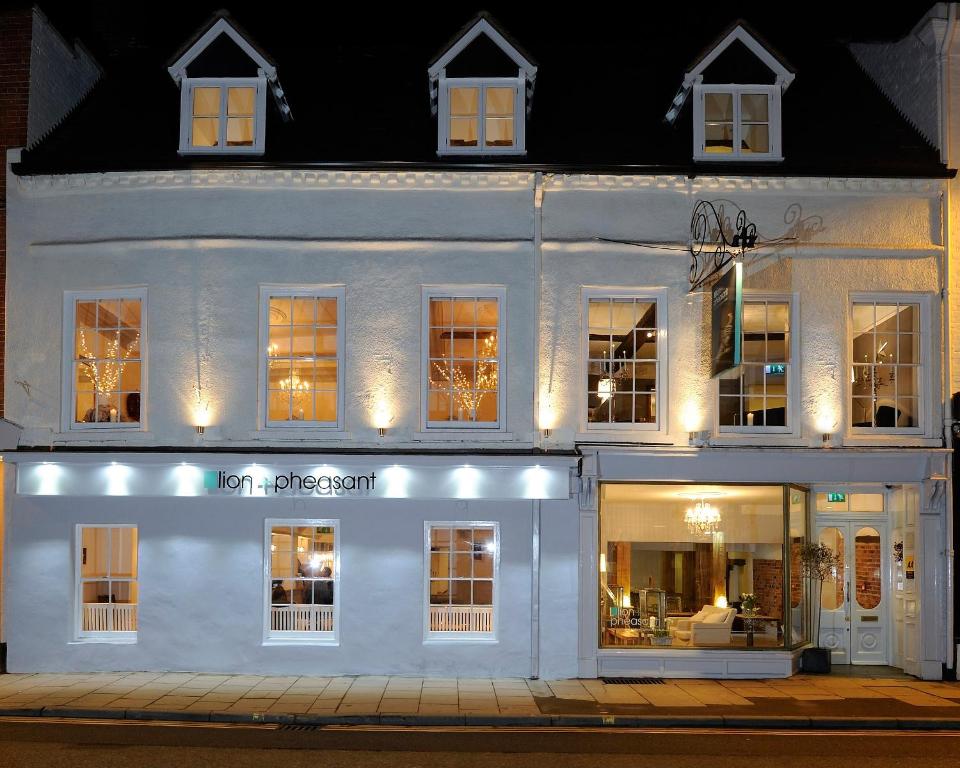 a white building with a store front at night at Lion & Pheasant Hotel in Shrewsbury