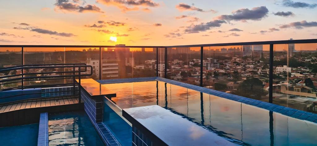 a rooftop pool on top of a building with a sunset at Reserva Madero Loft in Natal
