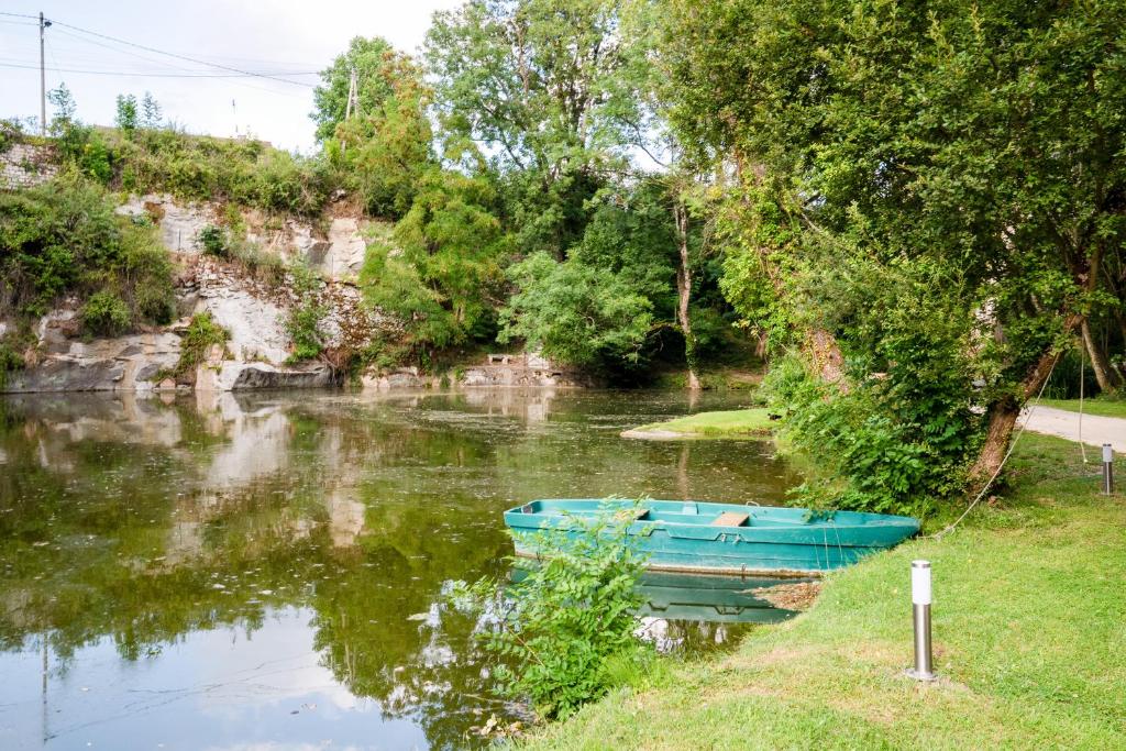 a blue boat sitting on the side of a river at Carrière de la Tour in Condé-sur-Sarthe