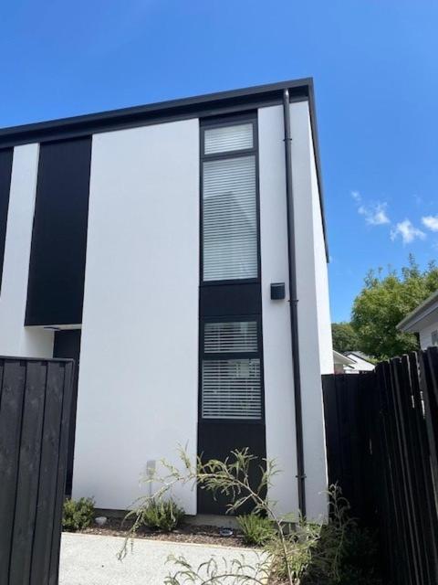 a black and white house with a black fence at Colombo Executive Apartments in Christchurch
