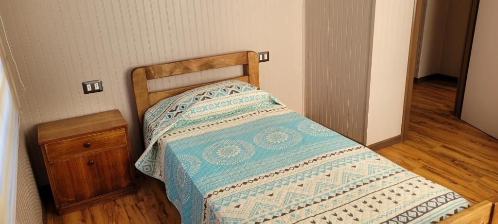a small bed in a bedroom with a wooden floor at Cabañas San Pedro in Arauco