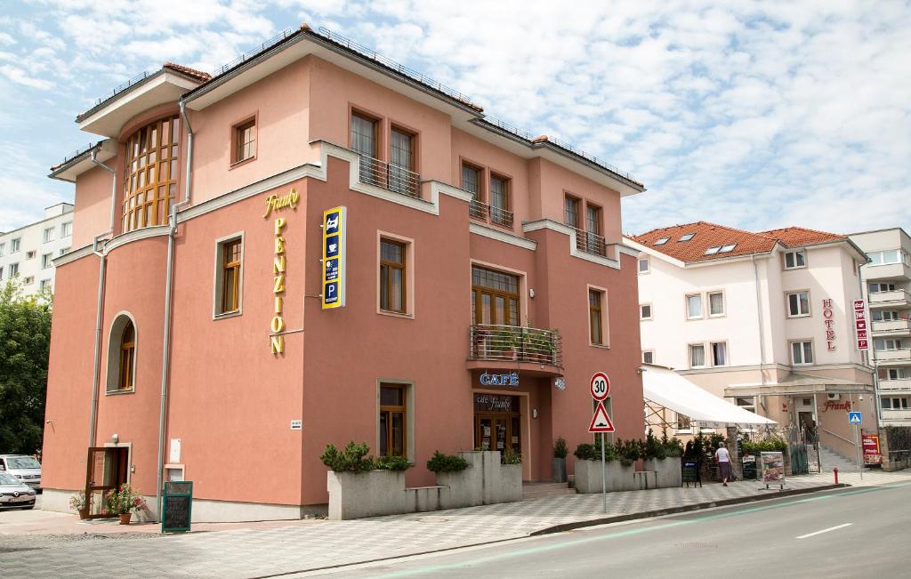 um edifício cor-de-rosa ao lado de uma rua em Penzion Franko em Zvolen