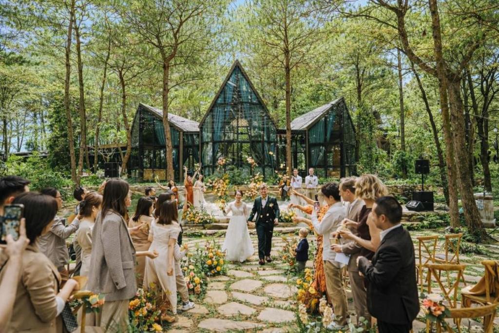 a bride and groom walking down the aisle at their wedding at Amaya Retreat in Sóc Sơn