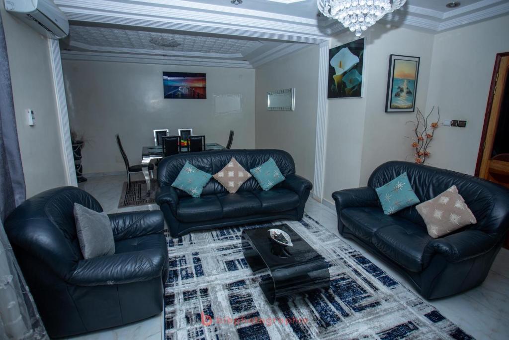 a living room with two leather couches and a table at Cabral residence in Guediawaye