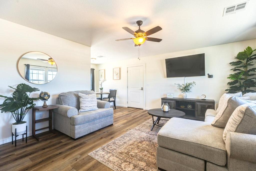 a living room with two couches and a flat screen tv at Stylish New Construction Home in Salina