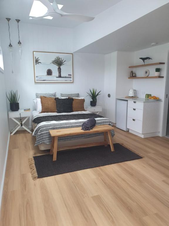 a bedroom with a bed and a bench in it at Seaclusion at Byron in Byron Bay