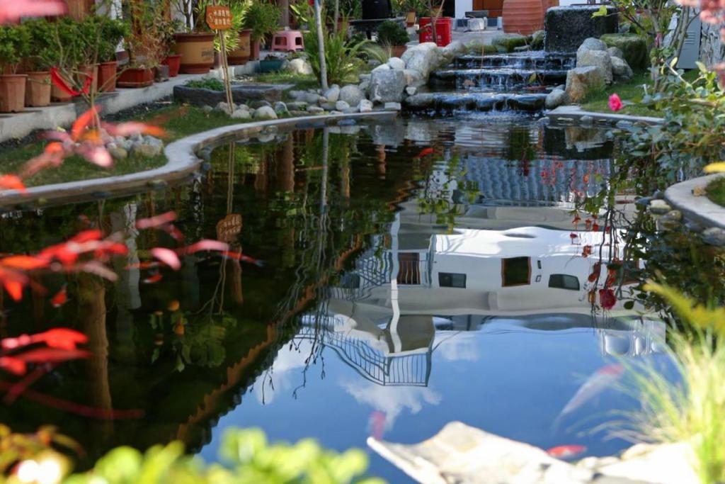 a pond in a garden with red fish in it at 赛家花园酒店SAI JIA Garden HOTEL in Dali Ancient Town