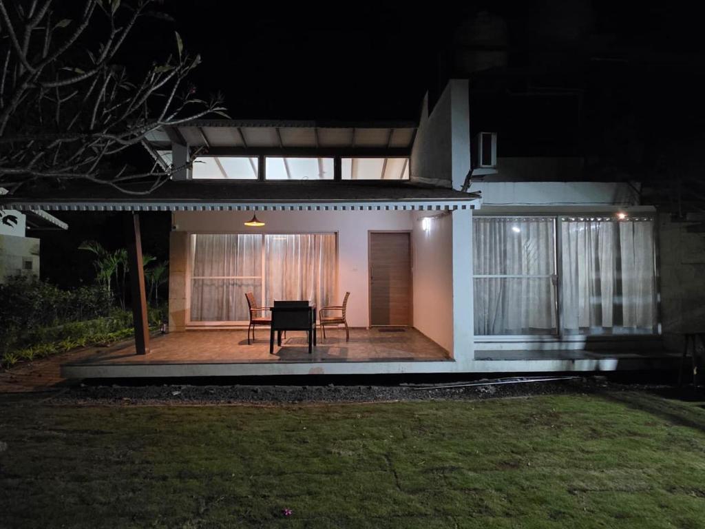 a small house with a patio at night at Kimaya Cottage - 2BHK 1 Washroom in Trimbak