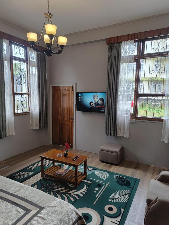a living room with a table and a couch at Beaumont Homestay 377 in Shillong
