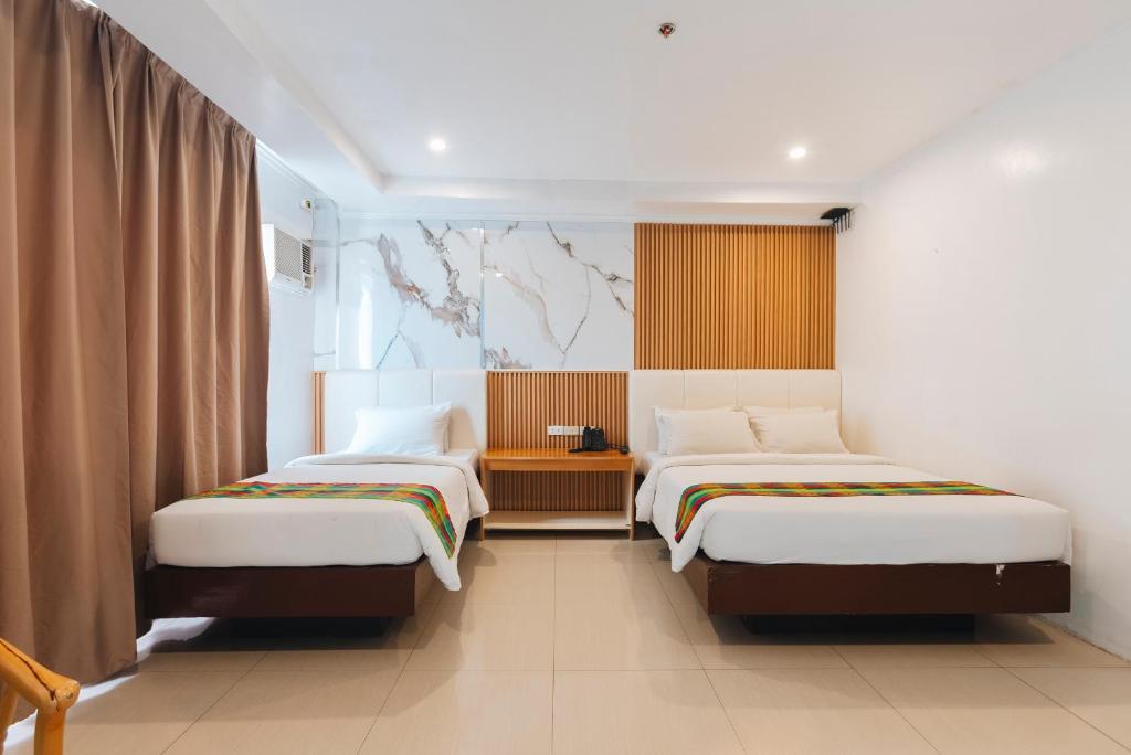 a bedroom with two beds and a window at LM METRO HOTEL in Zamboanga