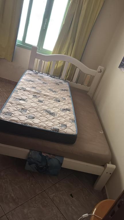 a small bed in a room with a window at Casa Zucchi in Itapema