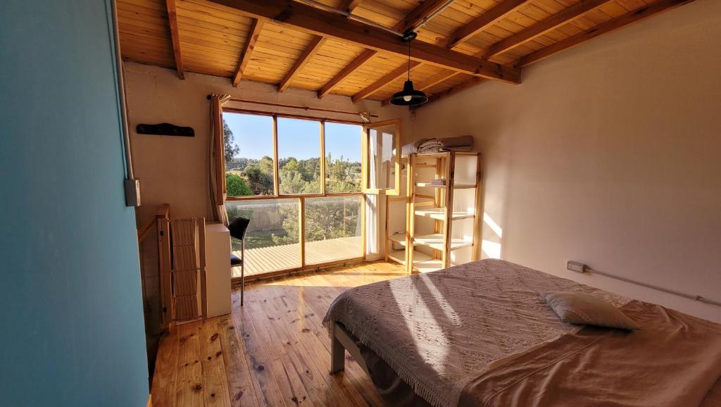 a bedroom with a bed and a large window at Casa Lavion in Colonia Chapadmalal