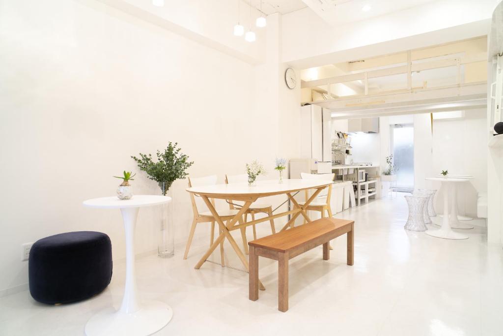 a white room with a table and chairs in it at Casa Blanca Guesthouse in Nagasaki