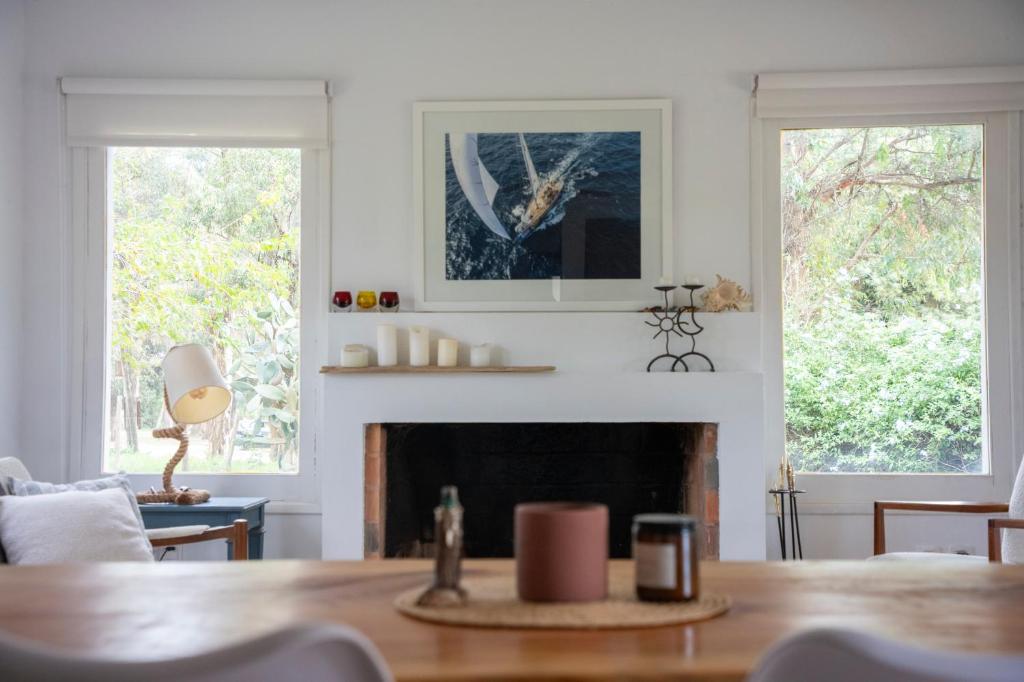 a living room with a fireplace and two windows at Casa Nopal in Punta del Este