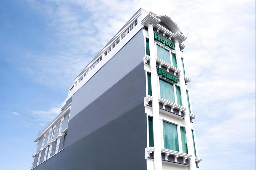 a tall white building with a sky in the background at Panen Hotel in Bandung