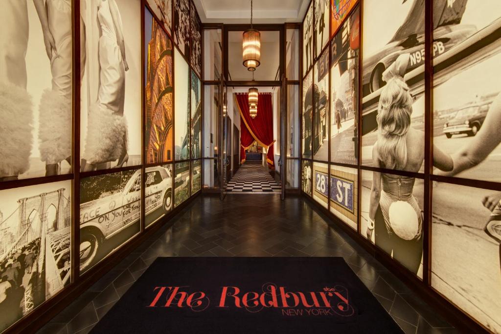 a hallway with art on the walls and a sign on the floor at The Redbury New York in New York