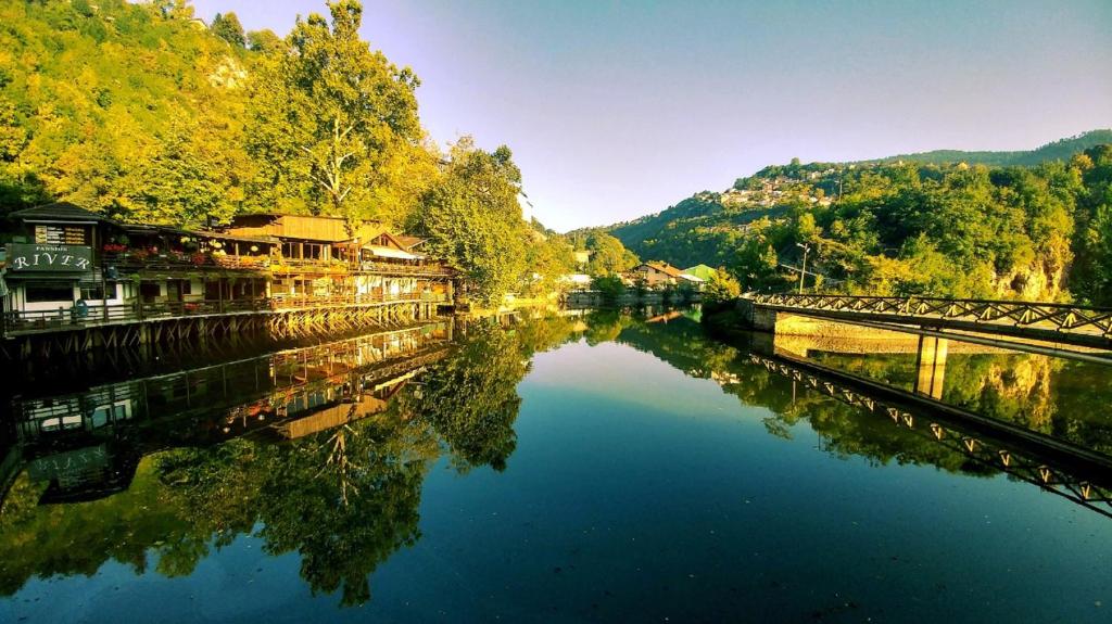 塞拉耶佛的住宿－潘申河酒店，享有河流、桥梁和树木的景色