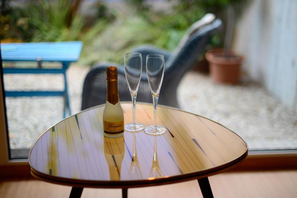 Chez Pio في مورتين: زجاجة من النبيذ وكأسين من النبيذ على الطاولة