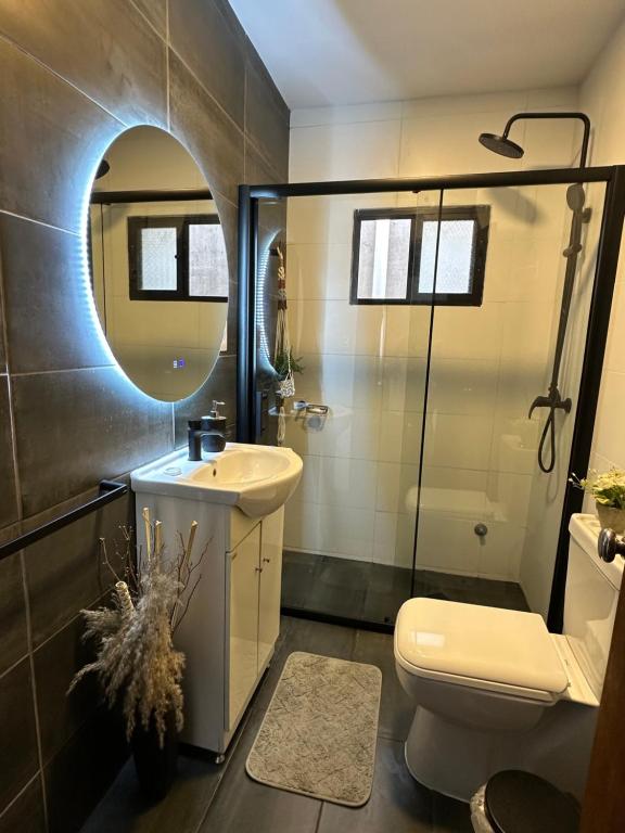 a bathroom with a toilet and a sink and a mirror at Casa independiente con estufa a leña in Minas