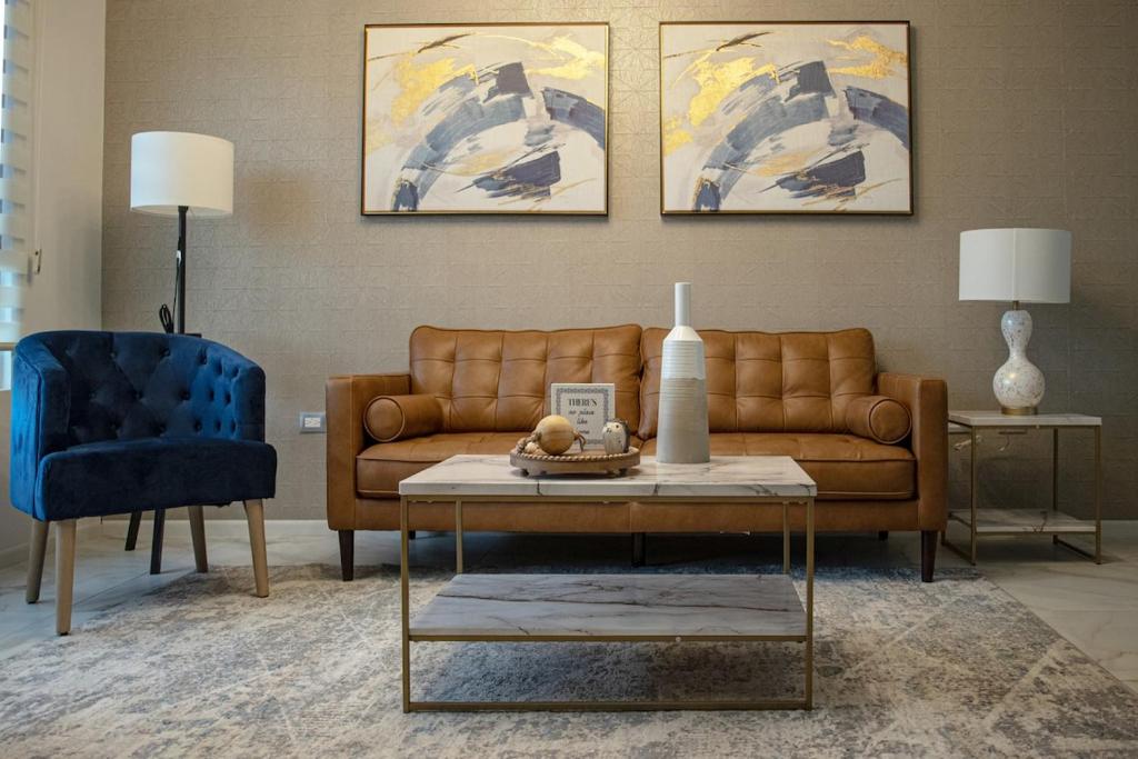 a living room with a brown couch and a blue chair at Casa Consulado Creta in Manuel F. Martínez