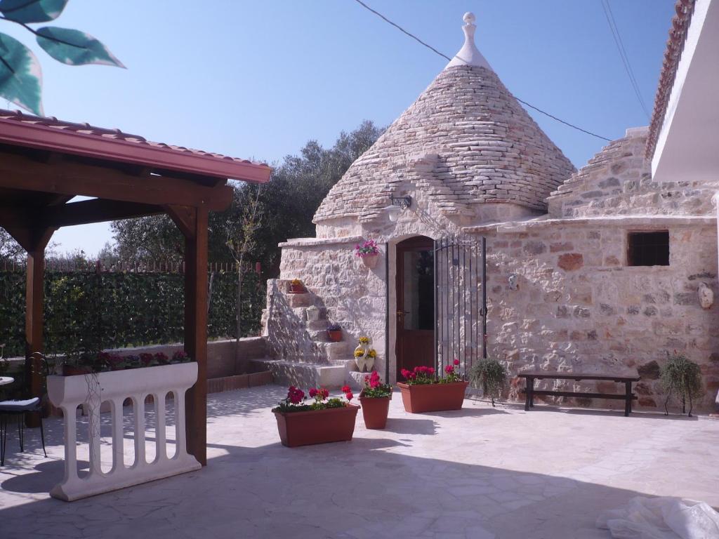 un edificio de piedra con escalera y porche en L'Isola Felice e Trulli Sotto Le Stelle, en Castellana Grotte