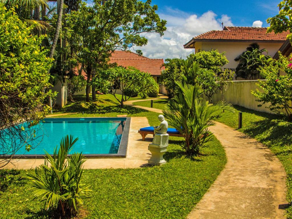 a garden with a swimming pool and a fountain at The Lagoon Villa in Negombo