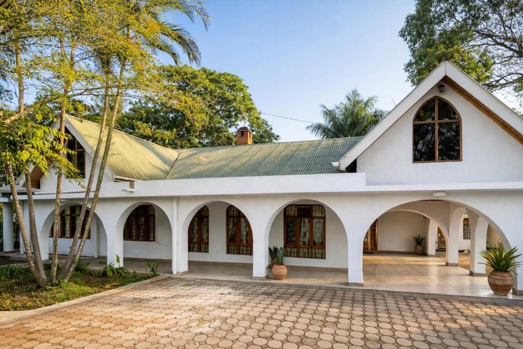 an old white building with a tiled courtyard at Toiwo Residence 4BR Home in Ilboru, Arusha in Arusha