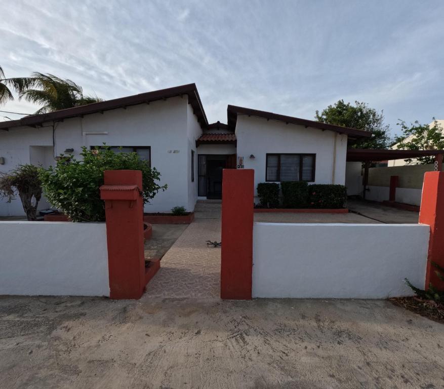 a white house with red posts in front of it at Palm Beach 278 in Palm-Eagle Beach