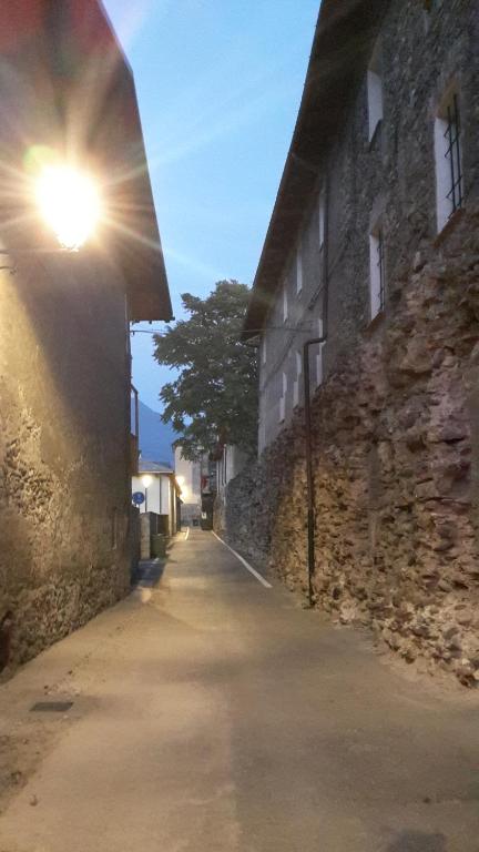 an alley with a street light next to a stone building at B&B Chanoux in Aosta