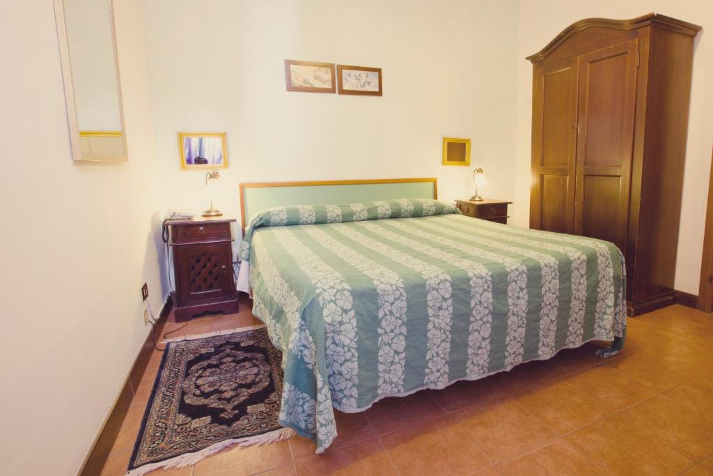 a bedroom with a bed with a green and white bedspread at Hotel Centrale in Viterbo