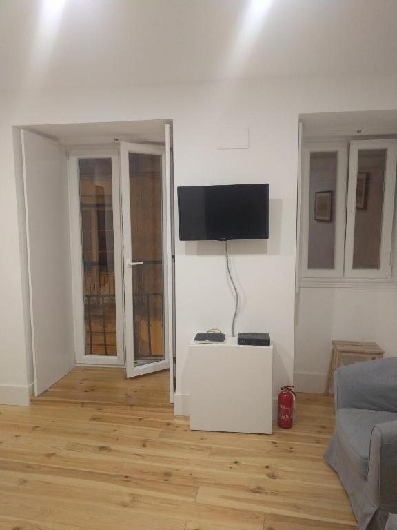 a white living room with a flat screen tv on the wall at VR Martim Moniz in Lisbon